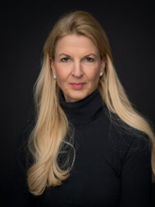 Stylische blonde Dame mit schwarzem Rollkragen-Pullover.